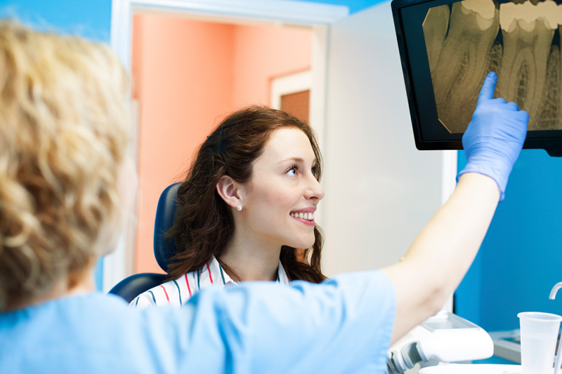 Image of a dental professional showing a digital x-ray to a patient at Aesthetic Periodontal & Implant Specialists.