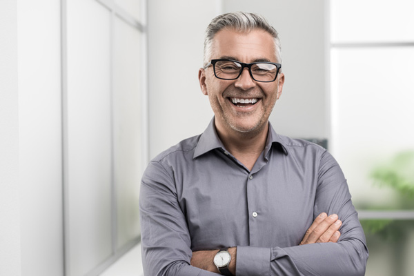 Man smiling with his arms crossed at Aesthetic Periodontal & Implant Specialists